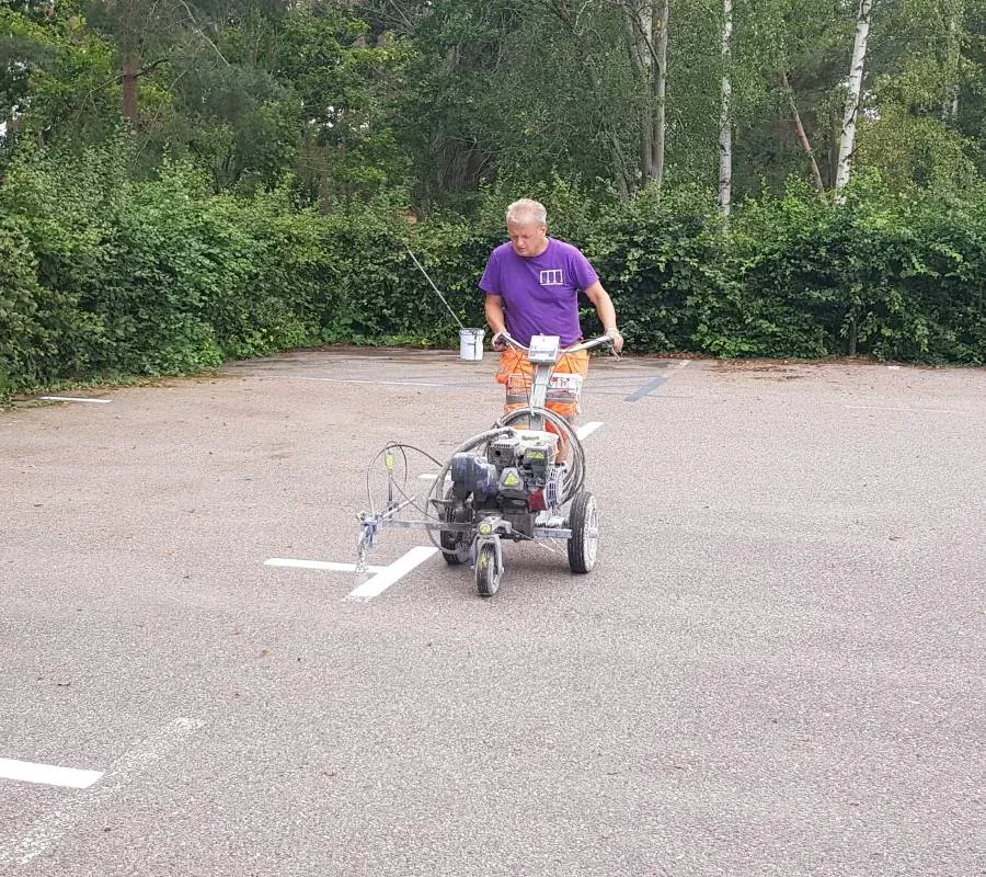 Linjemålning med maskin på en asfalterad yta