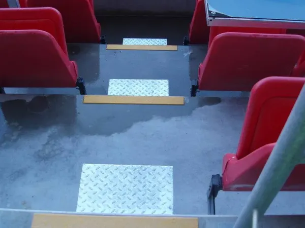 Kontrastmarkerade trappsteg mellan röda läktarstolar